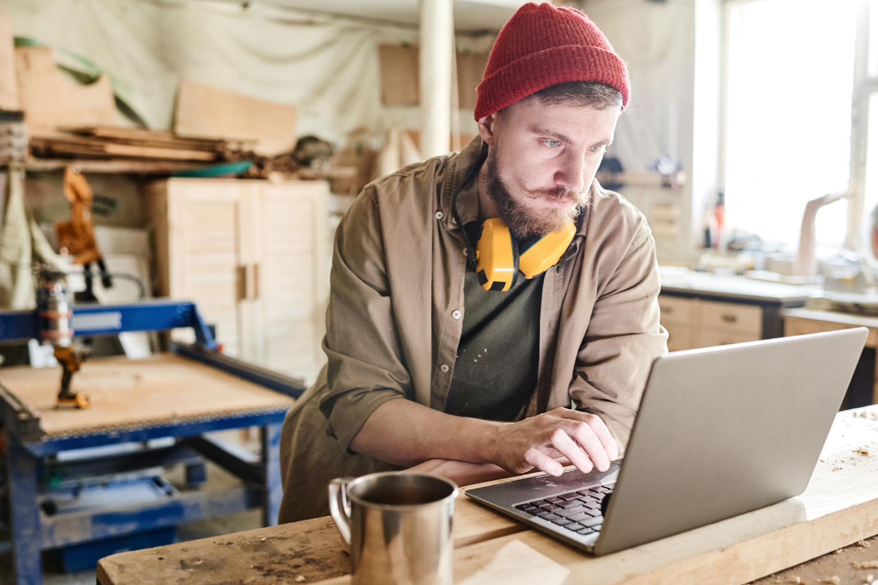 Handwerker mit Laptop in der Werkstatt